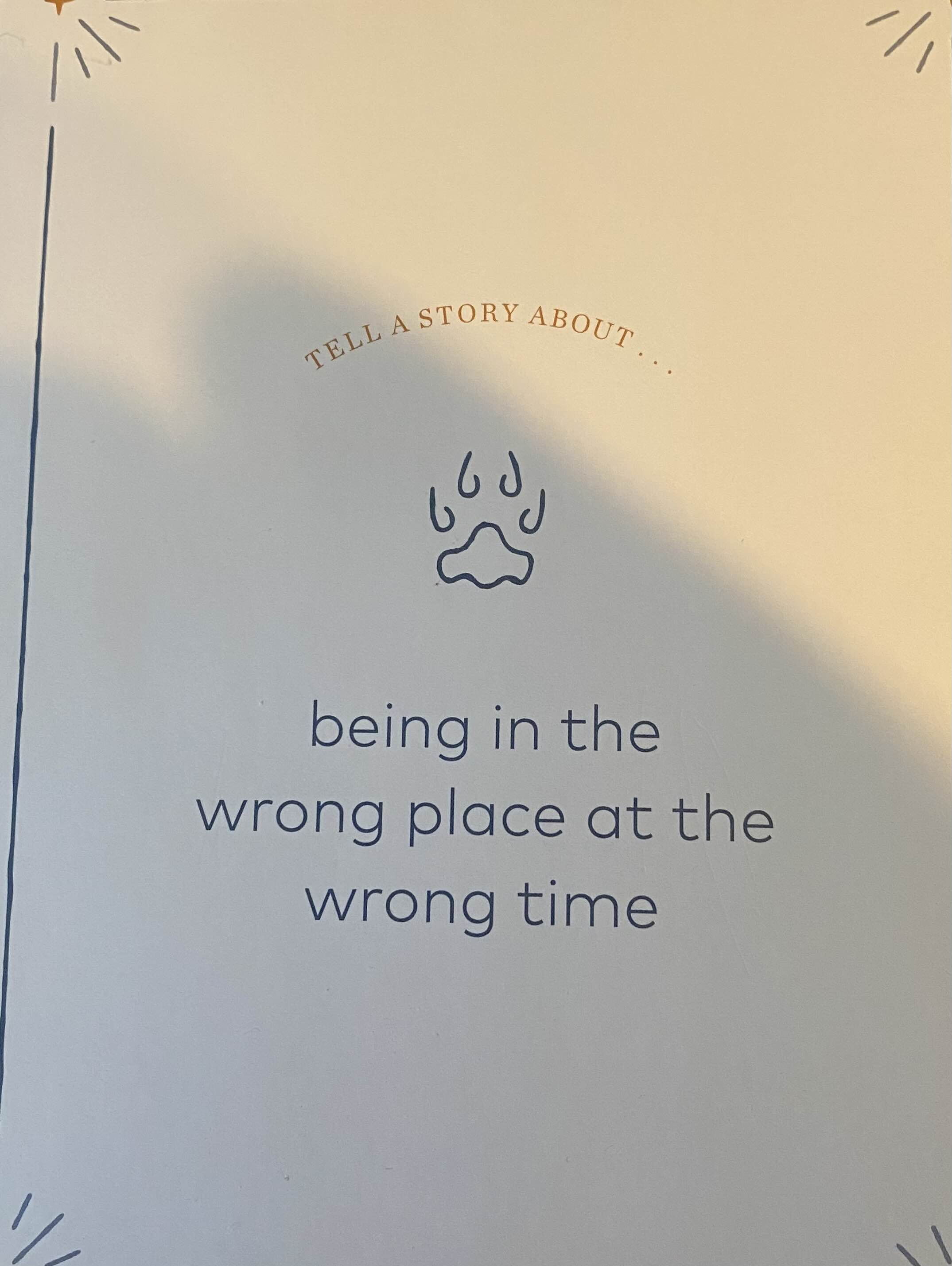 A printed story prompt card reading Tell a story about being in the wrong place at the wrong time.